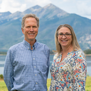 ummit Resort Group Real Estate Brokers Dan Burnett and Sam Meister on Lake Dillon with Peak 1 behind.